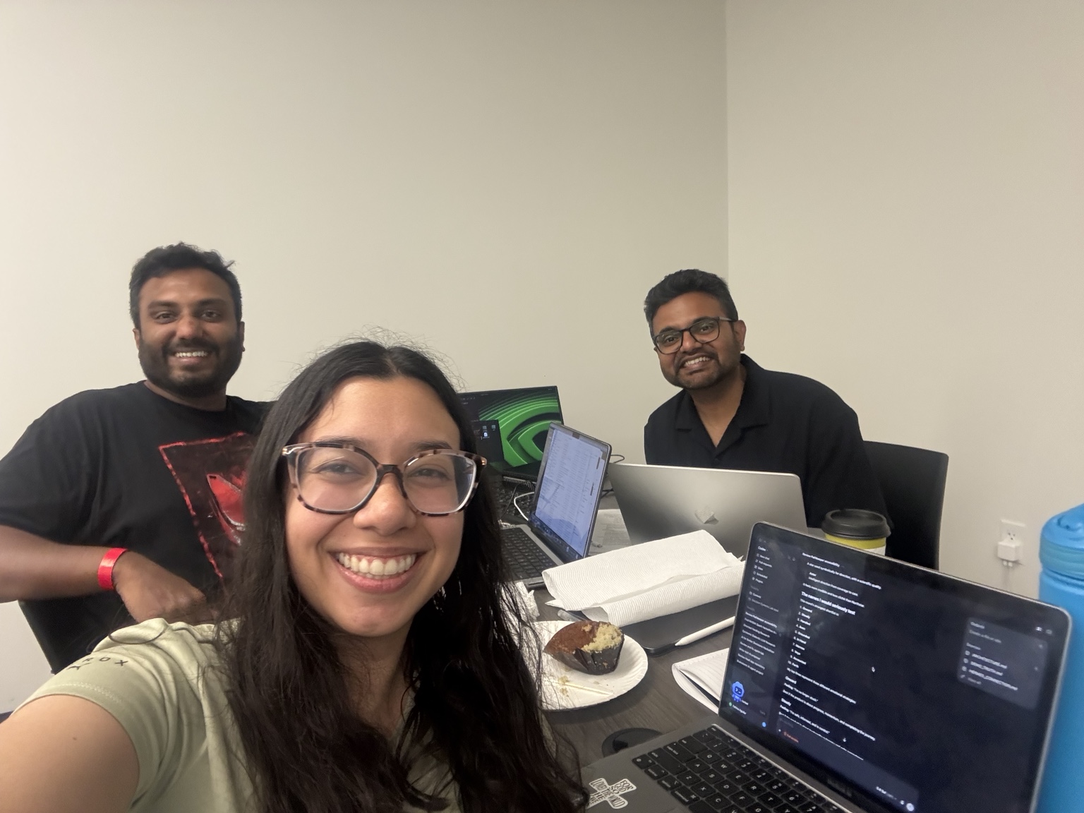 Three VELA team members at a shared table with open laptops during the Seattle build session.